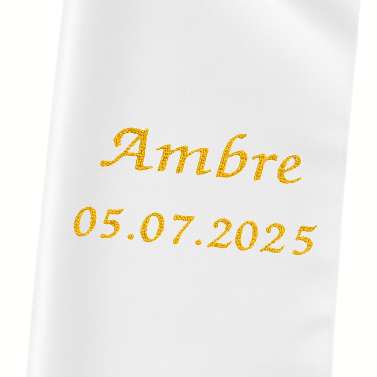 Gros plan du prénom « Ambre » et de la date 05.07.2025 brodés en fil doré sur l'étole bébé