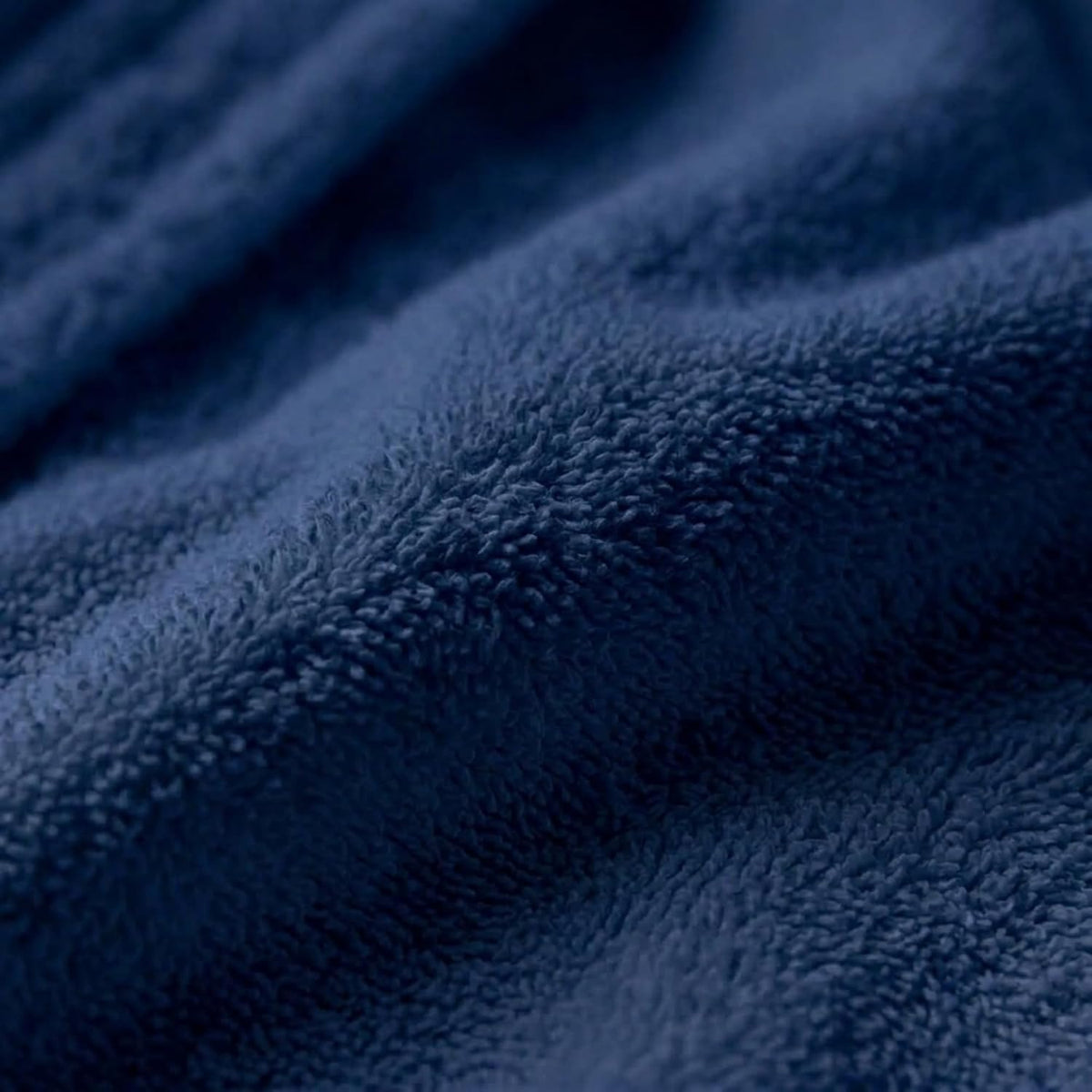 Gros plan de la texture éponge bleu marine du peignoir