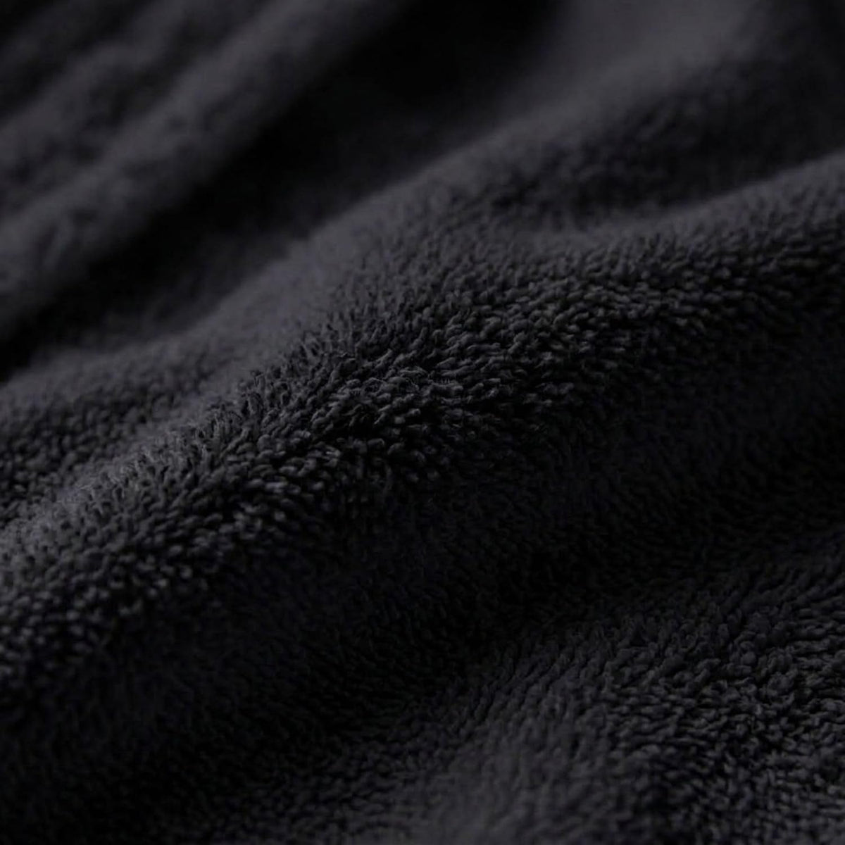Gros plan de la texture éponge noire du peignoir